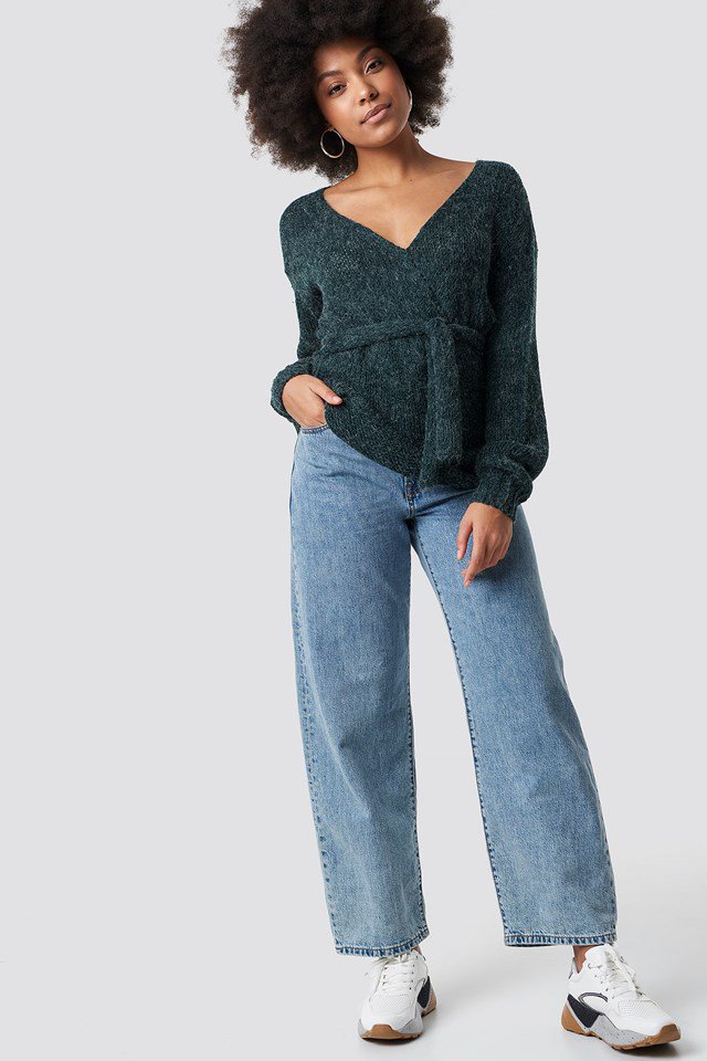 Green V-Neck Knitted Sweater with Wide Jeans and White Sneakers.